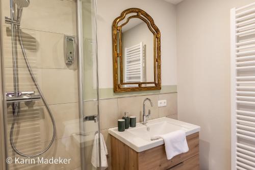 y baño con lavabo y ducha con espejo. en Design Ferienwohnung mit Bauerngarten, en Waldkirchen