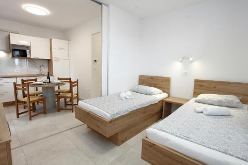 a room with two beds and a kitchen with a table at Sea View Apartments Portoroz ZM in Portorož