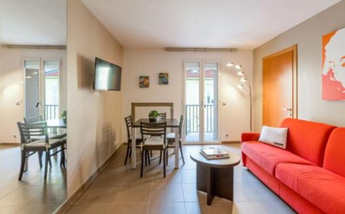 un salon avec un canapé rouge et une table dans l'établissement Suite Notre Dame - Appartements, à Cannes