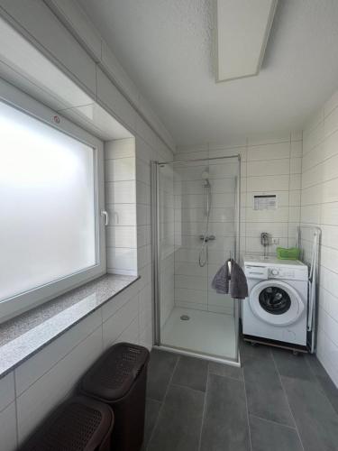 a bathroom with a washing machine and a shower at Montagewohnung/Grünberg in Grünberg
