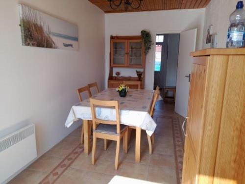 - une table à manger et des chaises dans la cuisine dans l'établissement Charmante villa 3 chambres, jardin clos, à 700m de la plage - rue calme et bien située - FR-1-324-26, à Saint-Hilaire-de-Riez
