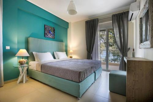 a bedroom with a bed and a blue wall at Eucalyptus suite sea view in Karavomylos