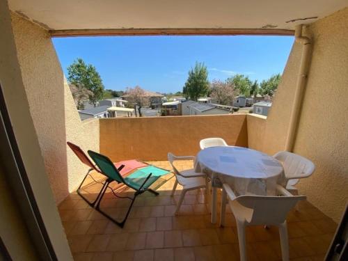 un patio avec une table et des chaises sur un balcon dans l'établissement Studio Confortable avec Terrasse et Parking Privé, 5 Couchages, Marseillan - FR-1-326-763, à Marseillan