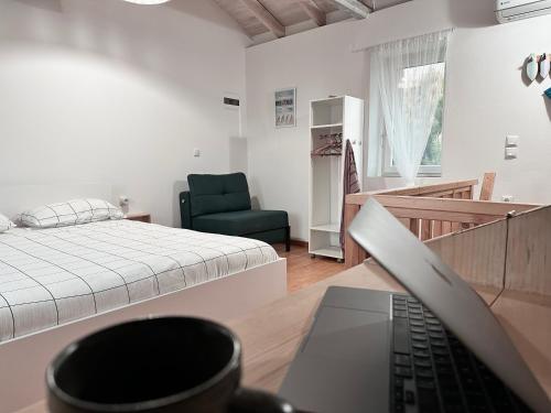 a bedroom with a bed and a laptop on a desk at Surf-themed stone house at Kalliopi 2 in Kalliópi
