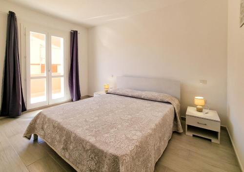 een slaapkamer met een bed en een groot raam bij Residenza Solari in La Maddalena