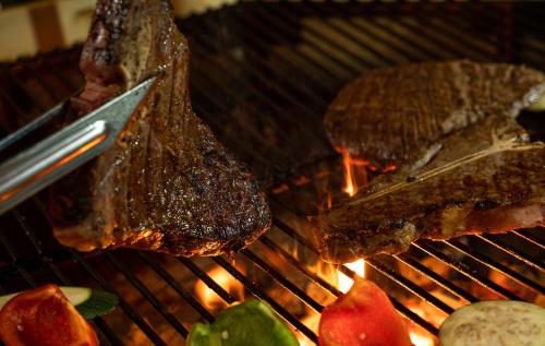 two pieces of meat on a grill with a knife at RECHTMURG 27 in Baiersbronn