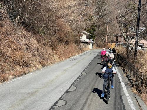 a group of people riding bikes down a road at Shoji Lake Hotel in Fujikawaguchiko