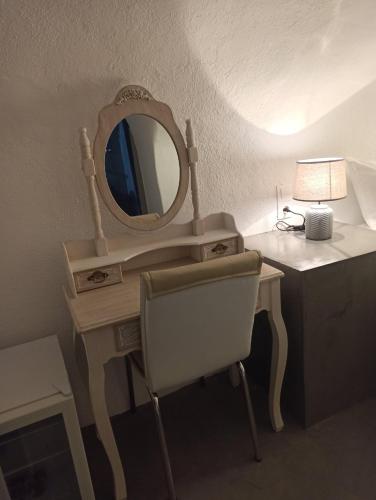 a dressing table with a mirror and a chair at AQUA SERENITY LUXURY SUITES SANTORINI in Foinikiá