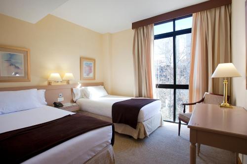 pokój hotelowy z 2 łóżkami i oknem w obiekcie Espahotel Plaza Basílica w Madrycie
