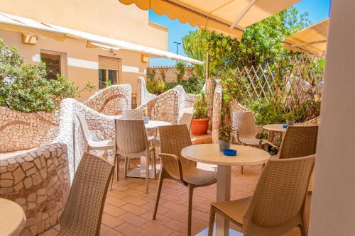 an outdoor seating area with tables and chairs at Hotel Kaly in Ventimiglia