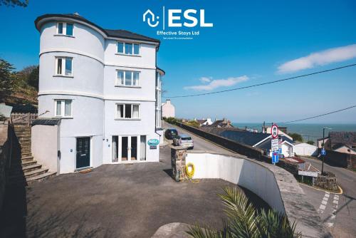 a white house on the side of a road at Beautiful En Suite 5 Bedroom Home with Sea Views in New Quay