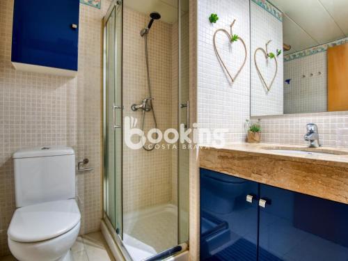 a bathroom with a toilet and a shower and a sink at Gavines del Port in Platja d'Aro