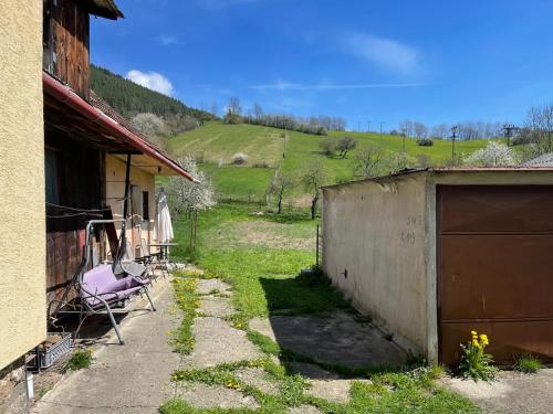 a yard with a fence and a building and a hill at Chalupa u Tomáša in Lúčky