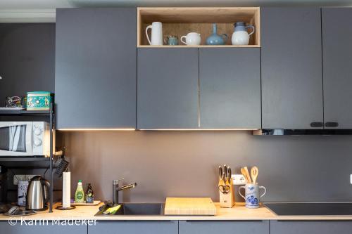 a kitchen with gray cabinets and a counter top at Design Ferienwohnung mit Bauerngarten in Waldkirchen