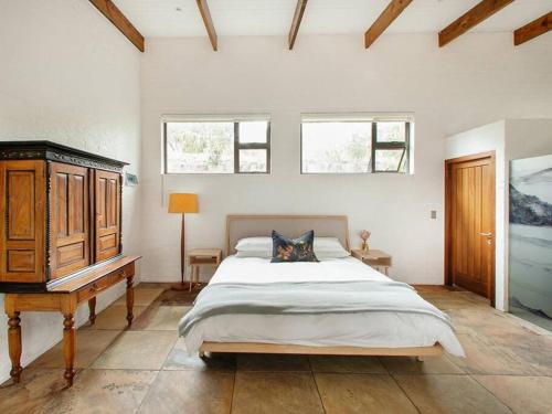 1 dormitorio con 1 cama, vestidor y 2 ventanas en Cloud 9 Woodland Studio en Kingfisher Creek