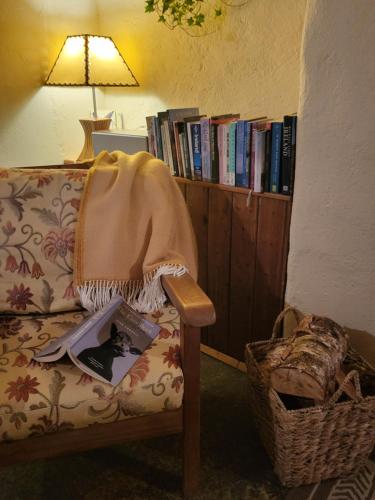a couch with a book on it next to a book shelf at Cnoc Suain in Galway