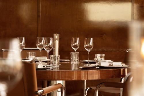 a table with wine glasses on it in a restaurant at Cap d'Antibes Beach Hotel in Juan-les-Pins