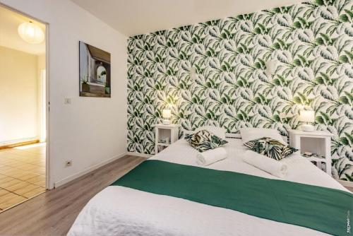 a bedroom with a large bed with a green and white wallpaper at Appartement la Toscanelle - Quartier historique - Gaillac in Gaillac