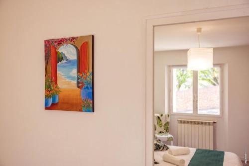 a painting hanging on a wall in a bedroom at Appartement la Toscanelle - Quartier historique - Gaillac in Gaillac