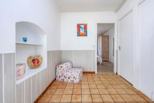 a living room with a chair and a tile floor at Appartement la Toscanelle - Quartier historique - Gaillac in Gaillac