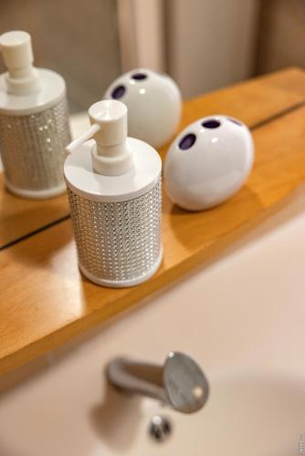 a bathroom sink with a soap dispenser on a shelf at Appartement la Toscanelle - Quartier historique - Gaillac in Gaillac