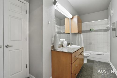 Baño blanco con lavabo y aseo en West Campus Accommodations Pool and King Bedrooms, en Austin