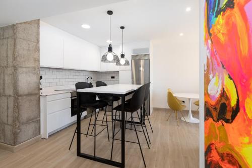 kuchnia ze stołem, krzesłami i obrazem w obiekcie ApartUP La Concha Beachfront II w mieście Oropesa del Mar