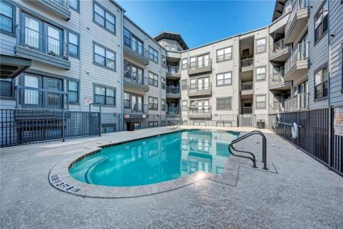 a swimming pool in front of a building at Extremely Comfortable King Beds in Super Cute Apt in Austin