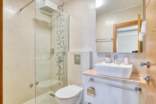 een badkamer met een toilet, een wastafel en een douche bij SYMPHONY in Petrovac na Moru