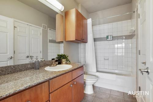 a bathroom with a sink and a toilet at Extremely Comfortable King Beds in Super Cute Apt in Austin