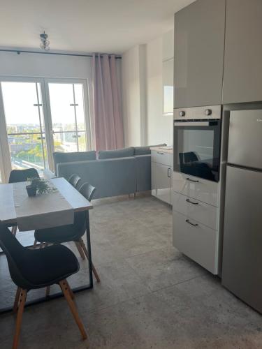 Il comprend une cuisine avec une table et un canapé. dans l'établissement Kasprzaka Beautiful City View Apartament, à Varsovie