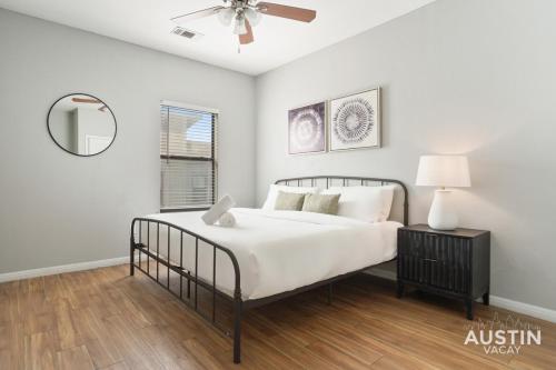 a white bedroom with a bed and a ceiling fan at King Beds and Memory Foam Sleeper in Vibrant ATX Apt in Austin