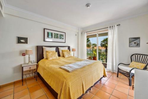 a bedroom with a bed with a yellow bedspread at Vila Sol with Pool, Garden & Rooftop Terrace in Quarteira