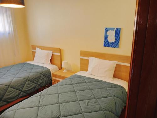 2 Betten in einem kleinen Zimmer mit ermottermott in der Unterkunft Pôr do Sol in Vila Nova de Gaia