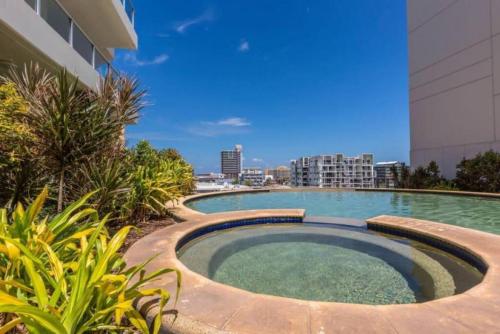 een zwembad aan de zijkant van een gebouw bij Pandanas Apt 7 15th fl with harbour and city views in Darwin