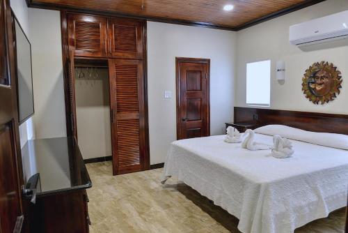 a bedroom with a bed with white towels on it at Beach House Condos, Negril in Negril