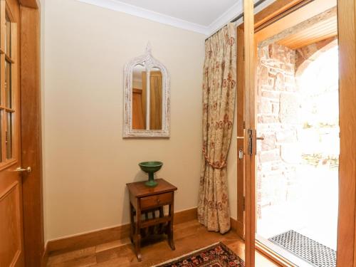 een hal met een deur en een tafel en een spiegel bij Glen Cruick in Kirriemuir