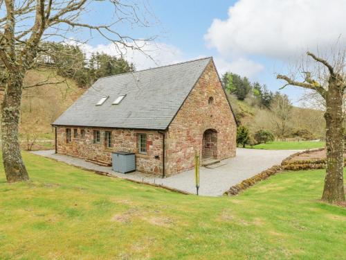 a brick barn with a garage in a field at Glen Cruick in Kirriemuir
