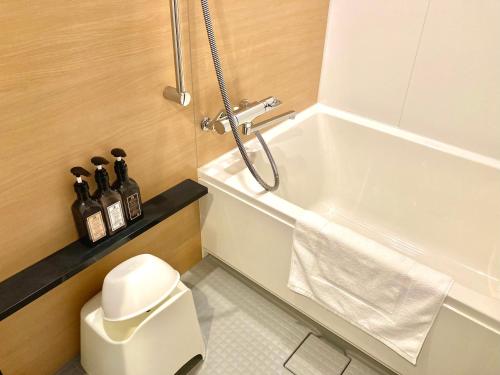 a bathroom with a shower and a toilet and a sink at Henn na Hotel Osaka Namba in Osaka