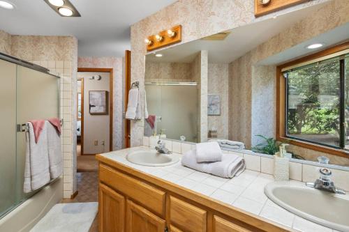 a bathroom with two sinks and a large mirror at Fairway View Retreat in Eugene