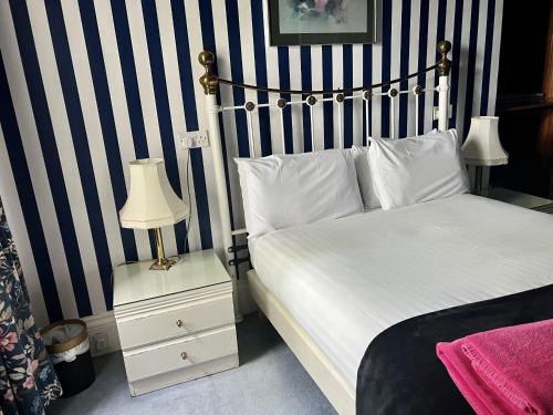 een slaapkamer met een bed met blauwe en witte strepen bij Eliza House in Edinburgh