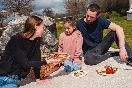 a woman and a man and a little girl eating food at HOTEL AGRI in Soběšice