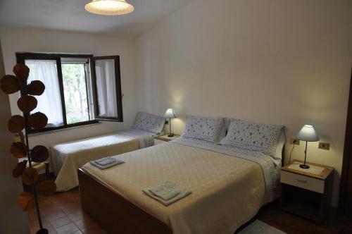 1 dormitorio con 2 camas y ventana en Bed & Breakfast Agriturismo San Macario, en Pula