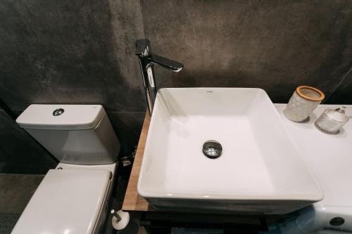 a bathroom with a white sink and a toilet at Lux Studio near Center in Heraklio Town