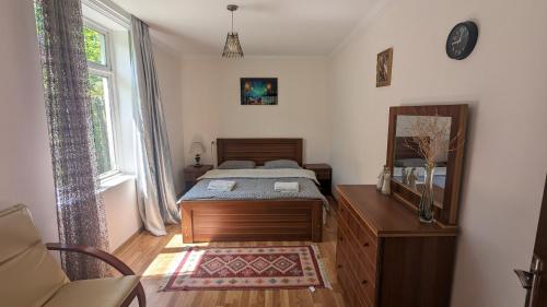 a bedroom with a bed and a dresser and a mirror at GreenHill - Your Guesthouse in Ubisa in Ubisi