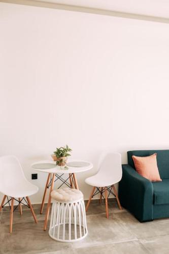 a living room with a couch and a table and chairs at Lux Studio near Center in Heraklio Town