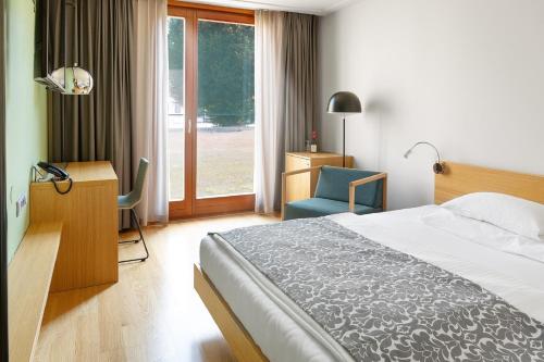 a bedroom with a bed and a desk and a chair at Hotel Schloss Hernstein in Hernstein