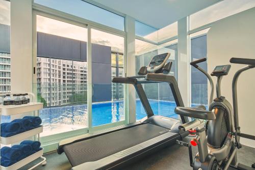 a gym with a treadmill and a large window at Citadines Connect City Centre Singapore in Singapore