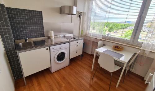 a small kitchen with a washing machine and a table at Horn Gästehaus in Leinfelden-Echterdingen