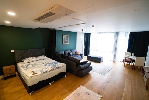 イスタンブールにあるPrime İstanbul Residances Deluxe King Studioのベッドルーム1室(ベッド1台、ソファ、椅子付)